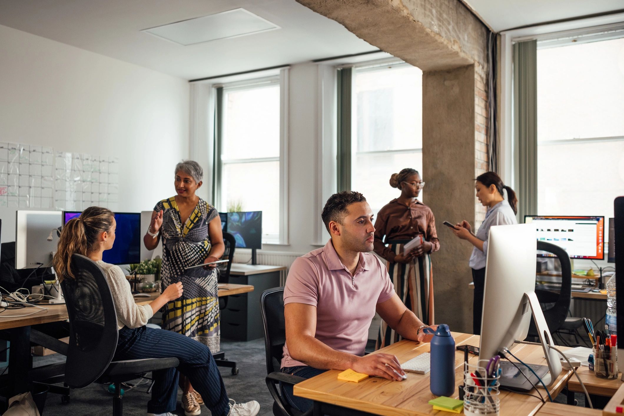 Office team working across desks and digital devices